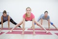 Group of positivel people practicing yoga in gym