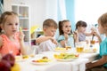 Group of preschool kids have a lunch in daycare. Children eating healthy food in kindergarten Royalty Free Stock Photo