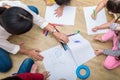 Group of preschool student and teacher drawing on paper in art c