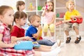 Group of preschooler children playing with musical toys at kindergarten