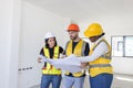 Group of professional construction workers engineers team meeting standing together work in new house construction site with floor