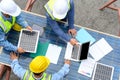 Group of professional engineering people wearing helmets and safety vests meeting with solar photovoltaic panels discussion for