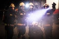 Group of professional firefighters posing. Firemen wearing uniforms, protective helmets and oxygen masks. Smoke and firetrucks Royalty Free Stock Photo