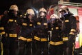 Group of professional firefighters posing. Firemen wearing uniforms, protective helmets and oxygen masks. Smoke and firetrucks in Royalty Free Stock Photo