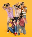 Group of professional photographers with cameras on orange background Royalty Free Stock Photo