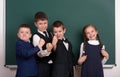 Group pupil as a gang, posing near blank chalkboard background, grimacing and emotions, dressed in classic black suit