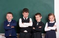 Group pupil as a gang, posing near blank chalkboard background, grimacing and emotions, friendshp and education concept