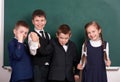 Group pupil as a gang, posing near blank chalkboard background, grimacing and emotions, friendshp and education concept