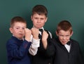 Group pupil as a gang, show knuckle, posing near blank chalkboard background, grimacing and emotions, dressed in classic black sui