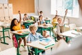 group of pupils raising hands to answer question during lesson Royalty Free Stock Photo