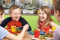 Group Of Pupils Sitting At Table In School Cafeteria Eating Meal Royalty Free Stock Photo