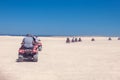 A group of quad bikes drive in the desert