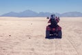 A group of quad bikes drive in the desert