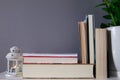Group of reading books on grey background and lantern with candle Royalty Free Stock Photo