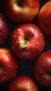 a group of red apples sitting on top of a black table covered in water droplets with a green leaf sticking out of the middle of Royalty Free Stock Photo