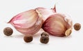 Group of red garlic cloves and black pepper balls. Isolated on white background Royalty Free Stock Photo