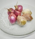 Group of red onions and part of garlic, organic food plants on plate.