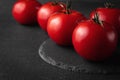 Group of red and ripe tomatoes making a frame on the dark black and gray textured background. template for advertising with copy Royalty Free Stock Photo