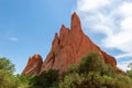 a group of red rocks with trees growing on them next to the road Royalty Free Stock Photo