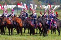 A group of reenactors dressed as Napoleonic war soldiers ride horses