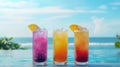 Group of refreshing tropical summer drinks with fruits and ice on tabletop on blurred ocean background