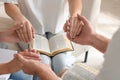 Group of religious people with Bibles holding hands and praying together indoors, closeup Royalty Free Stock Photo