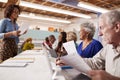 Group Of Retired Seniors Attending IT Class In Community Centre With Teacher