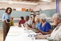 Group Of Retired Seniors Attending IT Class In Community Centre With Teacher Royalty Free Stock Photo