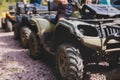 Group of riders riding ATV vehicle crossing forest rural road, process of driving rental vehicle, all terrain quad bike vehicle, Royalty Free Stock Photo