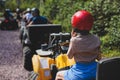 Group of riders riding ATV vehicle crossing forest rural road, process of driving rental vehicle, all terrain quad bike vehicle, Royalty Free Stock Photo