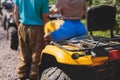 Group of riders riding ATV vehicle crossing forest rural road, process of driving rental vehicle, all terrain quad bike vehicle,