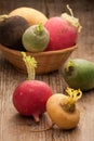 Group ripe variegated radishes in woven bowl