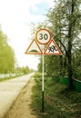 Group of road signs with speed limit, running around children, a dangerous section of a village road