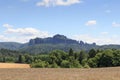 Group of rocks Schrammsteine and Falkenstein with grain field in Saxon Switzerland