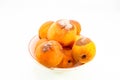 Group of rotten apricots in a ceramic bowl on white