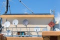 Group of Round White Parabolic Antennas on a Condominium Rooftop