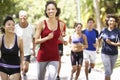 Group Of Runners Jogging Through Park