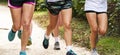 Group of runners legs on a dirt path