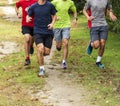 Group of runners training on a grass and dirt path