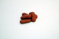 Group of rusty red colored tablets piled together with white background