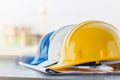 The group of safety helmet and the blueprint at construction site with crane background Royalty Free Stock Photo