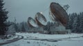 A group of satellite dishes in a snowy field, suitable for technology concepts Royalty Free Stock Photo