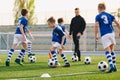 Group of schoolchildren playing training games with a young coach