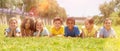 Group of school children resting on grass and smiling Royalty Free Stock Photo