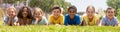 Group of school children resting on grass and smiling Royalty Free Stock Photo