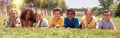 Group of school children resting on grass and smiling Royalty Free Stock Photo