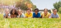 Group of school children resting on grass and smiling Royalty Free Stock Photo