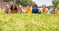 Group of school children resting on grass and smiling Royalty Free Stock Photo