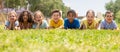 Group of school children resting on grass and smiling Royalty Free Stock Photo