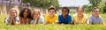 Group of school children resting on grass and smiling Royalty Free Stock Photo